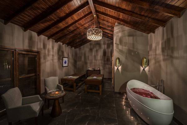 Spa-Behandlungsraum im Rixos Premium Tekirova Hotel mit Badewanne, Liegen und Deko.