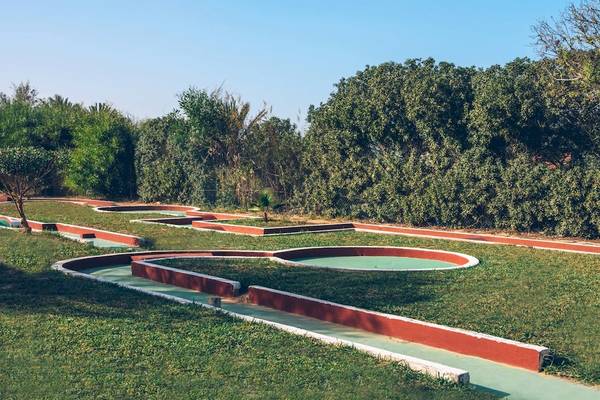 Golfplatz im Freien im Iberostar Mehari Djerba Hotel, umgeben von Bäumen und grünem Rasen.