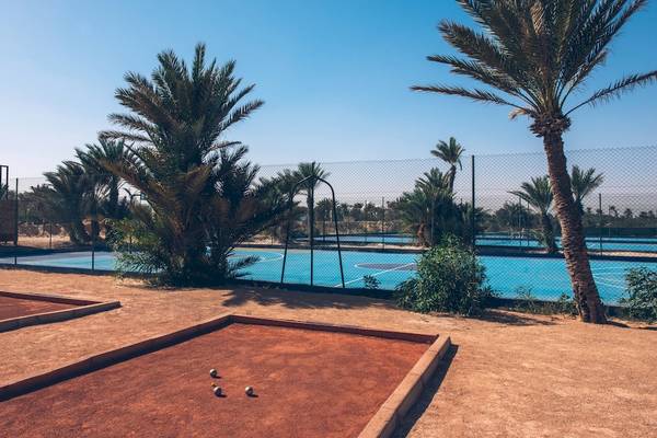 Tennisplätze des Iberostar Mehari Djerba Hotels in der Wüste mit Palmen und Sonnenschein