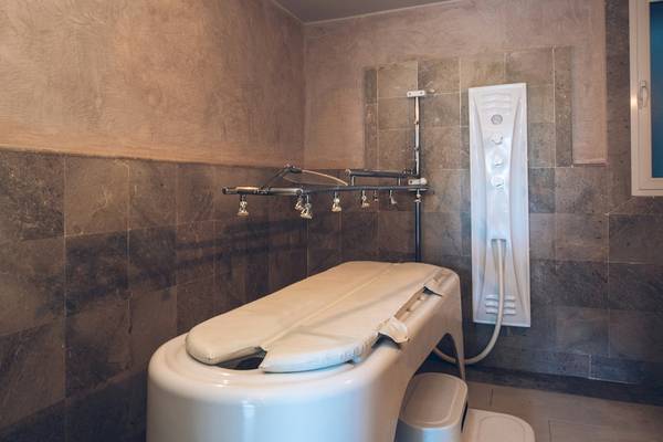 Badezimmer im Iberostar Mehari Djerba Hotel mit einer weißen Badewanne und grauen Fliesen.