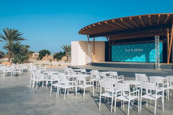 Außenbereich des Iberostar Mehari Djerba Hotels mit Bühne und weißen Stühlen.