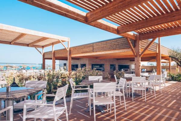 Außenterrasse des Iberostar Mehari Djerba Hotels mit weißen Stühlen und Tischen.