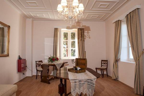 Innenansicht der Luxus Suite im Belvedere Hotel mit Esstisch, Stühlen und Dekor.