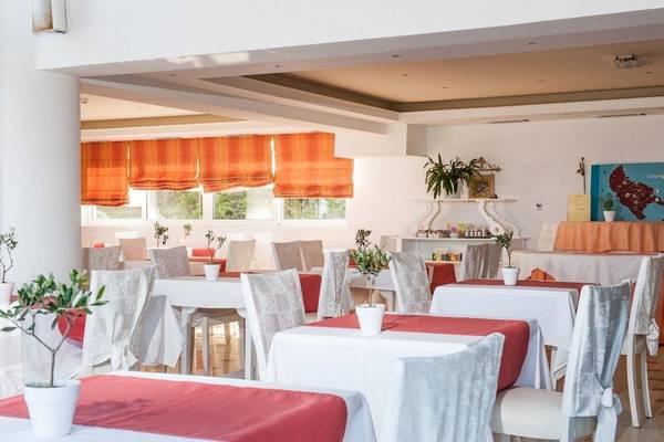 Restaurant im Belvedere Luxury Suites Hotel mit roten Tischdecken und Pflanzen.