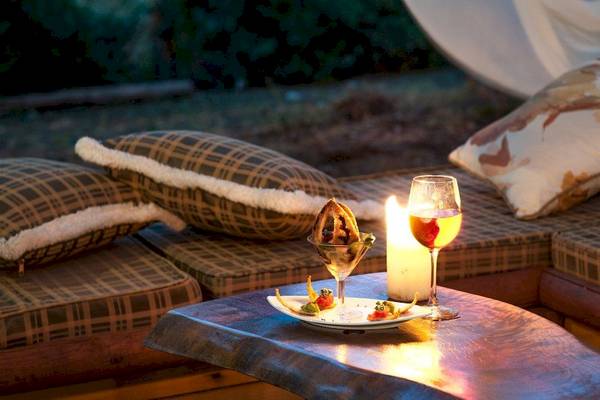 Abendessen auf der Couch im Hotel Belvedere mit Essen, Wein und Kerzenlicht.