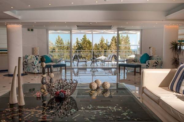 Empfangsbereich des Belvedere Luxury Suites Hotels mit Aussicht auf einen Wald.