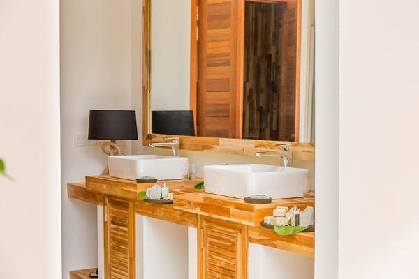 Badezimmer im Kudafushi Resort & Spa mit zwei Waschbecken und einem großen Spiegel.