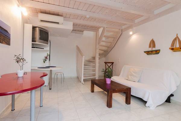Ein modernes Wohnzimmer mit einer Treppe, einem Sofa, einem Tisch und einem Fernseher.