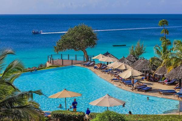 Außenpool mit Sonnenliegen und Sonnenschirmen am Royal Zanzibar Beach Resort.