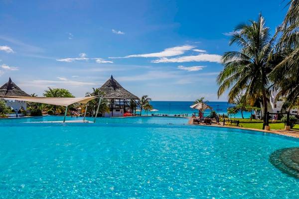 Außenpool des Royal Zanzibar Beach Resort mit Blick auf das Meer und tropische Palmen