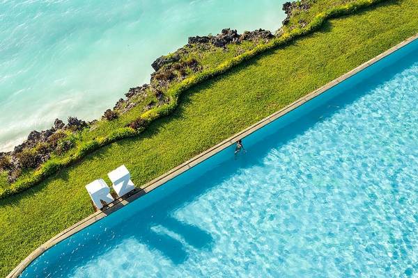 Ein Schwimmbad am Royal Zanzibar Beach Resort mit einer Person, die schwimmt.