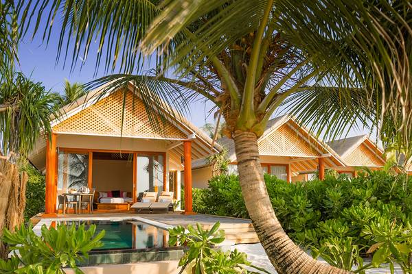 Bungalow des Kudafushi Resorts & Spa mit privatem Pool, umgeben von Palmen und Pflanzen.