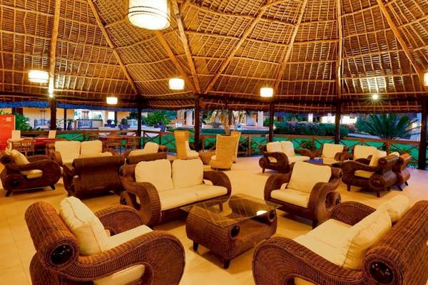 Royal Zanzibar Beach Resort Lounge Bereich mit Rattan Möbeln und einem Glastisch.