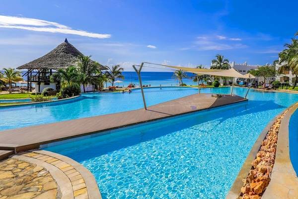 Royal Zanzibar Beach Resort Pool mit blauem Wasser und Sonnenschirmen