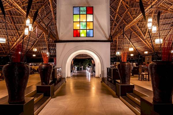 Innenansicht des Royal Zanzibar Beach Resorts mit gepflastertem Boden und dekorativen Vasen.