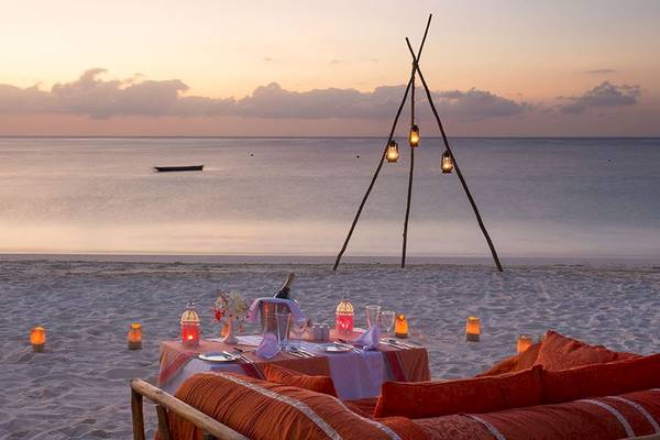 Dinner-Setting am Strand des Royal Zanzibar Beach Resort mit Kerzen und Flasche