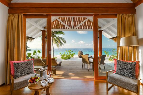 Innenraum des Kudafushi Resorts & Spa mit Blick auf das Meer und eine Terrasse.