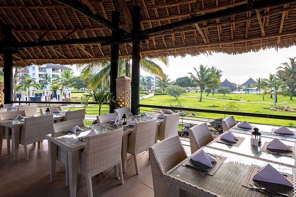 Restaurantbereich im Royal Zanzibar Beach Resort mit Blick auf die Terrasse und Grünflächen.