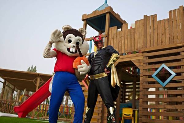 Zwei Maskottchen vor einem hölzernen Spielplatz im Rixos Hotel