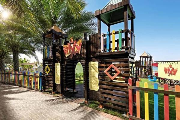 Kinderspielplatz im Rixos The Palm Hotel & Suites mit bunten Holzelementen und Spielturm