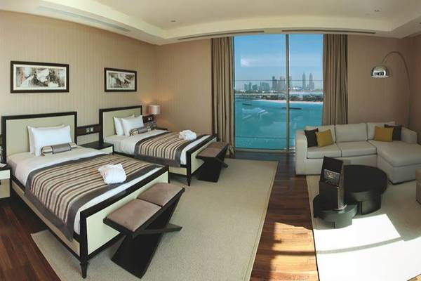 Suite mit Meerblick im Rixos The Palm Hotel & Suites mit zwei Betten und Wohnzimmerbereich.