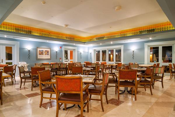 Innenansicht eines Restaurants im Chedi El Gouna Hotel mit runden Tischen und Stühlen.