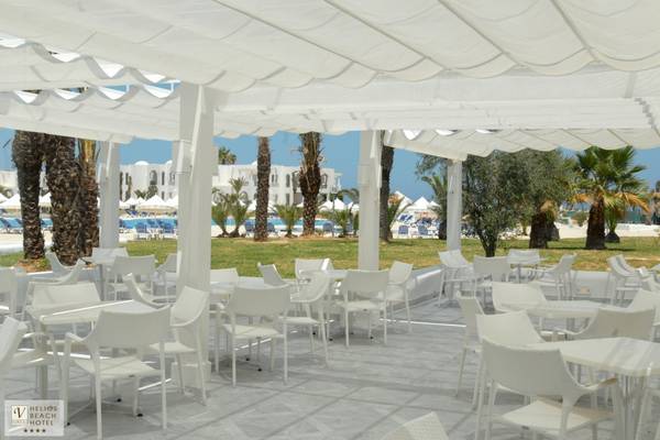 Terrasse des Vincci Helios Beach Hotel mit weißen Räumen und Palmen