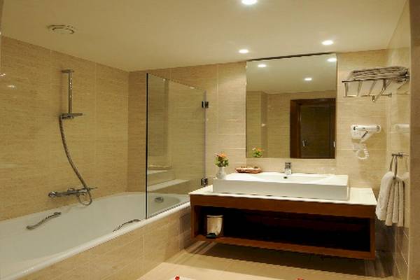 Ein Badezimmer mit Badewanne, Waschbecken und Spiegel im Vincci Helios Beach Hotel.