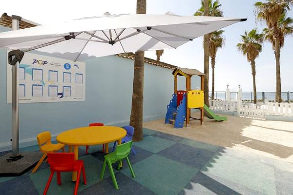 Kinderspielplatz des Playabonita Hotels mit bunten Stühlen, Tisch und Spielgeräten.