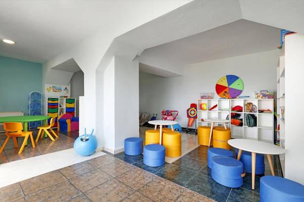 Spielzimmer im Playabonita Hotel mit bunten Stühlen, Tischen und Spielzeug.
