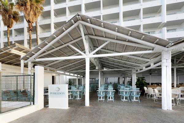 Außenbereich des Poseidon Restaurants im Playabonita Hotel mit Tischen und Stühlen unter einem Pavillon