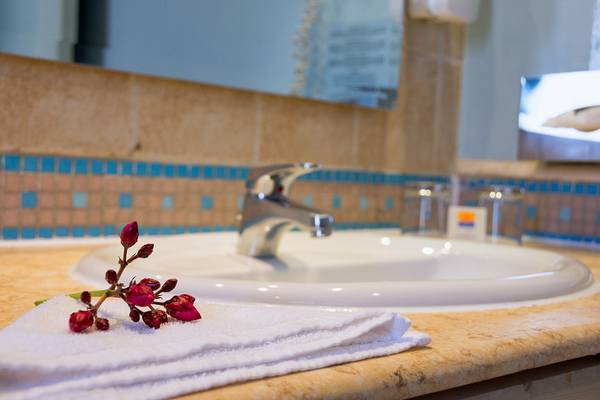 Badezimmer im Chedi El Gouna Hotel mit einem Handtuch und Blumen auf dem Waschbecken.