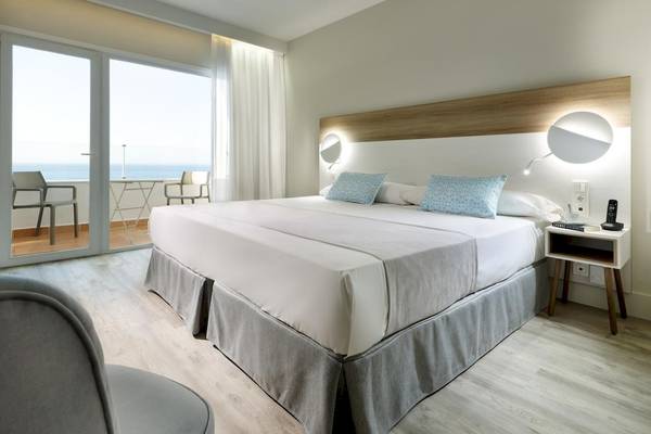 Hotelzimmer von Playabonita Hotel mit Meerblick und Balkon, inklusive bequemem Bett und Nachttisch.