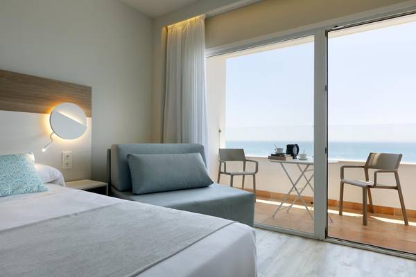 Playabonita Hotel Zimmer mit Meerblick und Balkon, Bett, Sofa und Esstisch.
