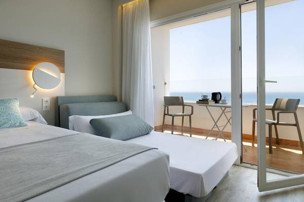 Doppelzimmer im Playabonita Hotel mit Meerblick, zwei Betten, einem Tisch und Stühlen auf dem Balkon.