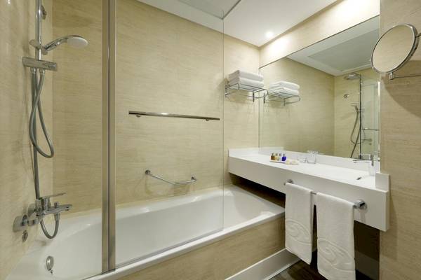 Modernes Badezimmer mit Badewanne, Handtüchern und Spiegeln im Playabonita Hotel.