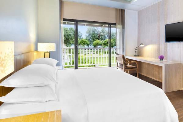 Hotelzimmer im Dusit Thani Krabi Beach Resort mit Bett, Schreibtisch und Fernseher.