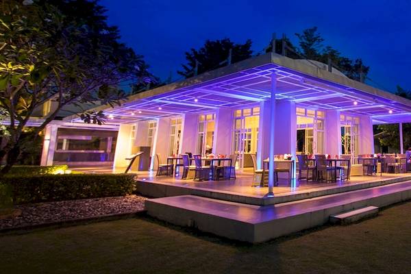 Alfresco-Essbereich des Dusit Thani Krabi Beach Resorts bei Nacht mit lila Beleuchtung