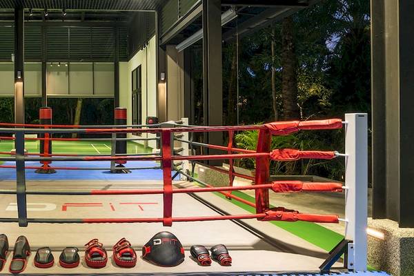 Boxring im Dusit Thani Krabi Beach Resort mit roten Ringpfosten und Trainingsausrüstung.
