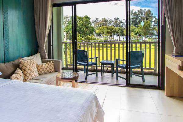 Innenansicht eines Hotelzimmers im Dusit Thani Krabi Beach Resort mit Blick auf eine Terrasse und Landschaft