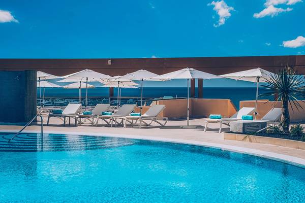 Pool-Terrasse des Iberostar Selection Fuerteventura Palace mit Lounge-Sesseln und Sonnenschirmen.