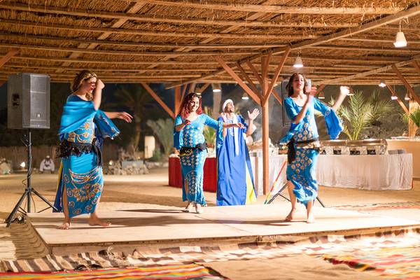 Drei Tänzerinnen in blauen Kleidern auf der Bühne im Chedi El Gouna Hotel.