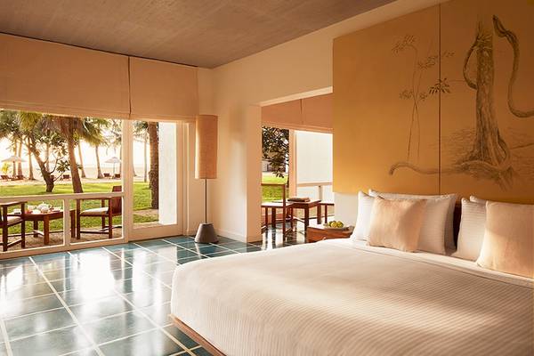 Schlafzimmer im Jetwing Blue Hotel mit Aussicht auf den Strand und grüner Landschaft