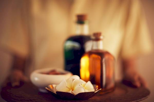 Tablett mit Aromatherapie-Flaschen und Blumen im Jetwing Blue Hotel.