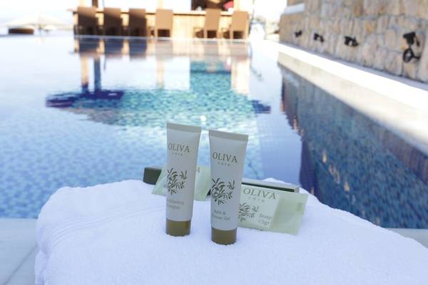Pool am Almira Hotel mit Olivenpflegeprodukten auf einem Handtuch.
