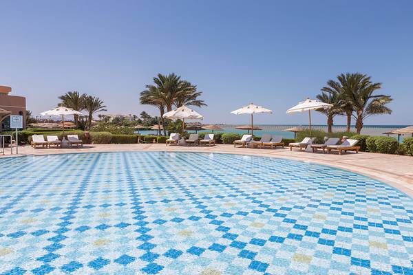 Außenpool des Chedi El Gouna Hotels mit Liegen und Sonnenschirmen.