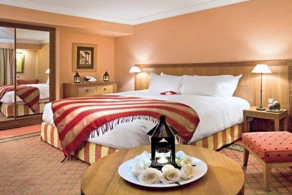 Hotelzimmer im Sofitel Marrakech Lounge & Spa mit Bett, Tisch, Rosen und Lampe