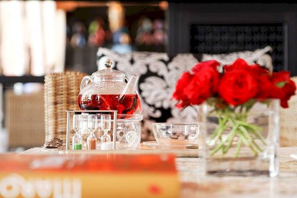 Tisch mit Teekannen, Gläsern und roten Rosen im Sofitel Marrakech Lounge.