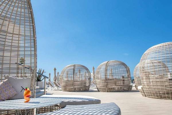 Loungebereich des Guayarmina Princess Hotels mit modernen Rattanmöbeln und Blick auf das Meer.
