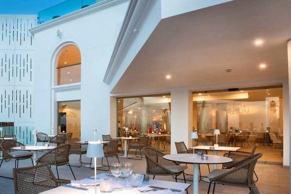 Terrasse des Guayarmina Princess Hotels mit Tischen, Stühlen und Palmen im Hintergrund